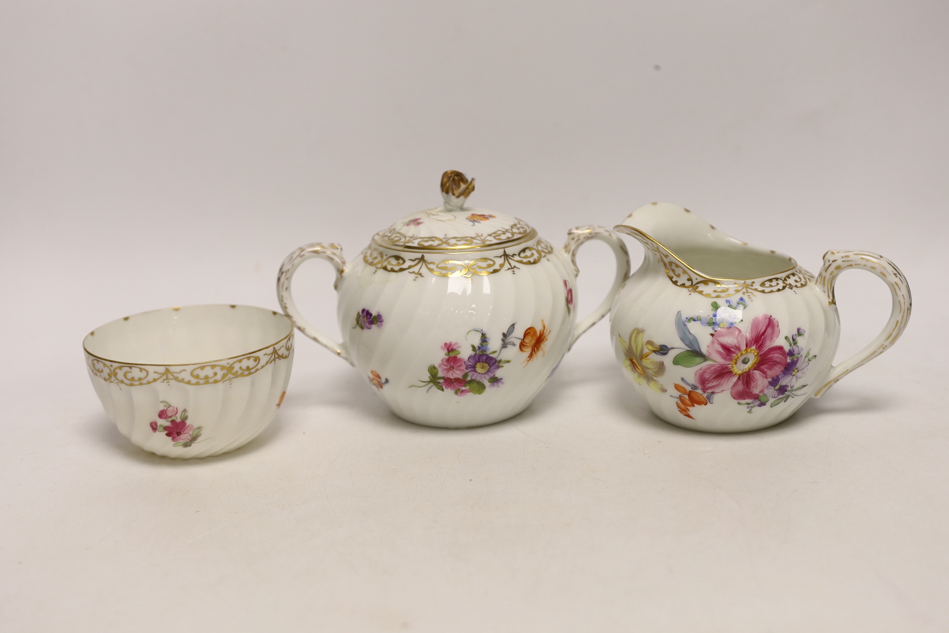 A Nymphenburg floral decorated teapot, milk jug and sugar bowl, teapot 13c high